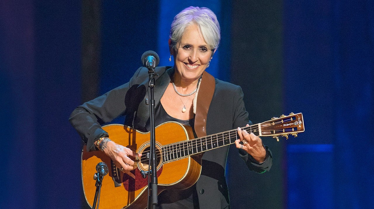 Na imagem a compositora norte-americana Joan Baez tocando seu violão modelo Parlor num show em Nova York em 2016. 