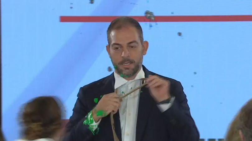 Imagem de Ministro do Ambiente atacado com tinta verde em conferência