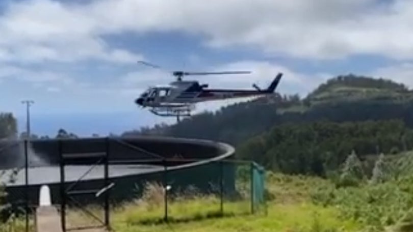 Imagem de Helicóptero combate incêndio que lavra em zona de mato e floresta nos Canhas