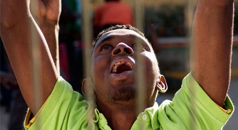 Um emigrante festeja o sucesso ap&oacute;s atravessar as barreiras que protegem o enclave espanhol de Meilla em Marrocos, dia 28 de fevereiro de 2014 (Reuters)