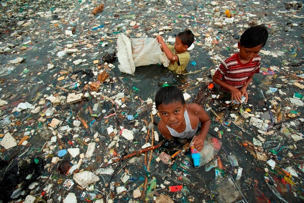 Crianças recolhem lixo de uma zona aquática em Jakarta - Indonésia

