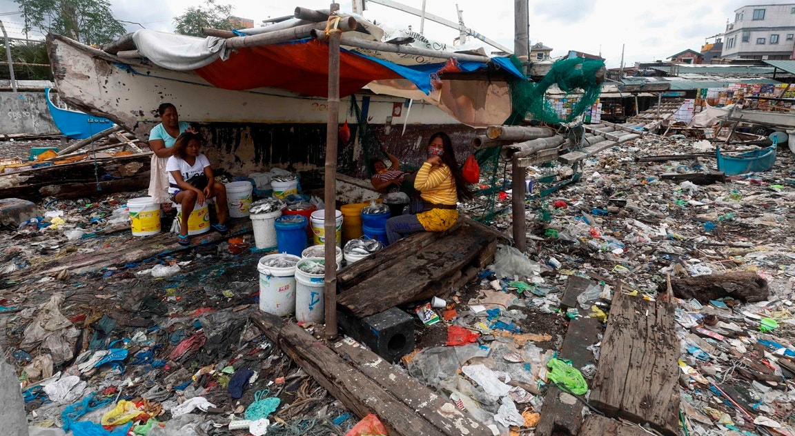  Filipinas, Manila. Peixeiras descansam entre lixo | Rolex Dela Pena - EPA |  