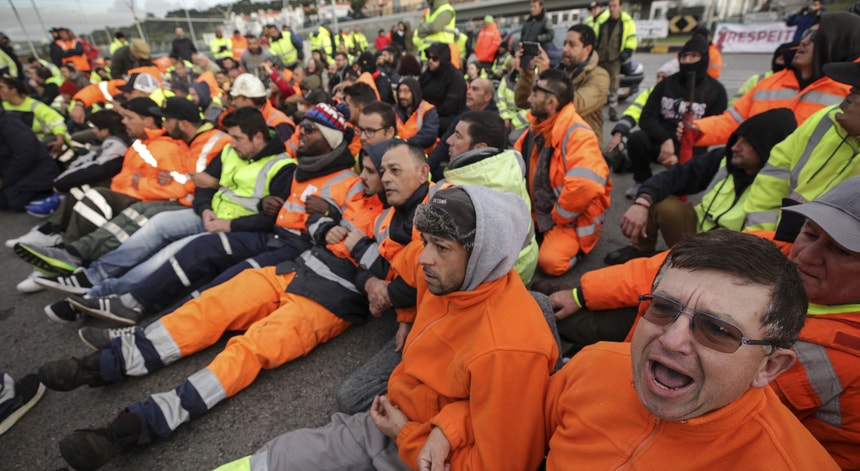 Os estivadores sentaram-se no chão e tentaram impedir que a polícia assegurasse a passagem do autocarro com trabalhadores substitutos
