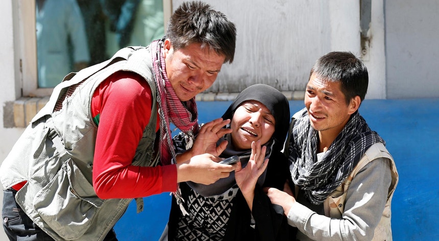Familiares de vítimas do ataque deste domingo junto ao hospital de Cabul, no Afeganistão
