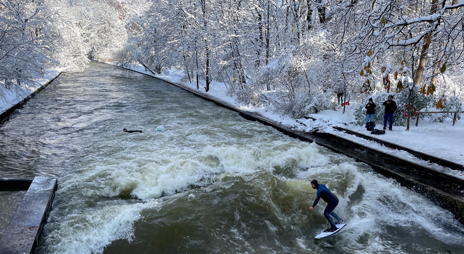  Um homem surfa nas ondas do rio Eisbach, um dia depois de um forte nev&atilde;o ter atingido a Baviera e a capital Munique, Alemanha, 3 de dezembro | Louisa Off - Reuters 