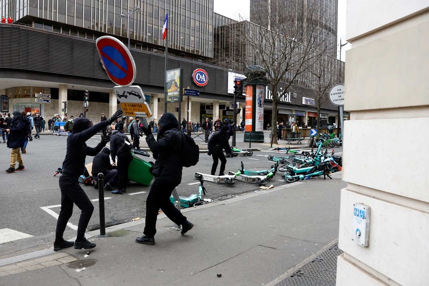 Manifestantes tentam retirar um sinal de trânsito das ruas de Paris no oitavo dia de protestos nacionais contra a reforma das pensões. 
