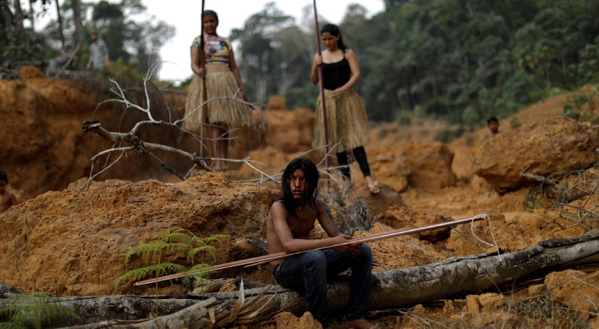 Na imagem, membros de uma tribo indígena mostram parte de uma área desflorestada da Amazónia.
