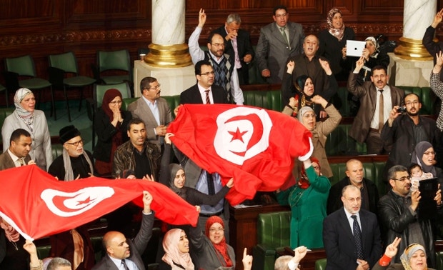 Deputados da Tunísia festejam a 26 de janeiro de 2014 a aprovação da nova Constituição do país, considerada um modelo de consensos e capaz de levar o país a tornar-se uma democracia moderna
