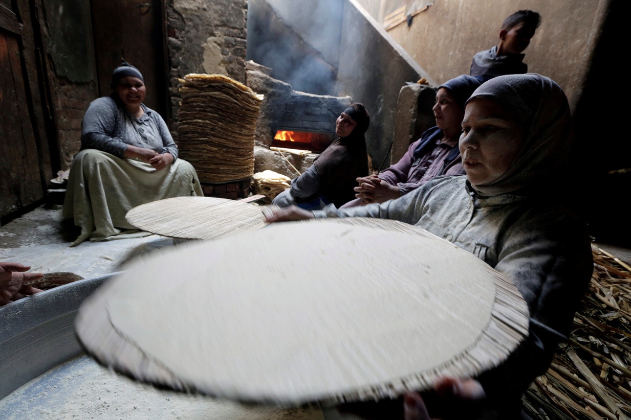 Egipto. Em Beni Suef, mulheres mu&ccedil;ulmanas confecionam o p&atilde;o tradicional para venderem durante o Ramad&atilde;o | Hayam Adel - Reuters 