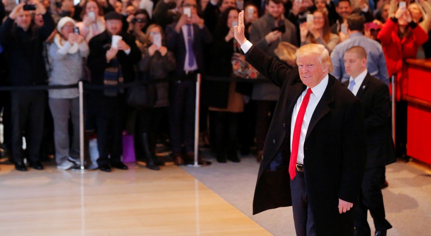 O Presidente-eleito Donald J. Trump cumprimenta a multidão reunida na entrada do <i>New York Times</i>
