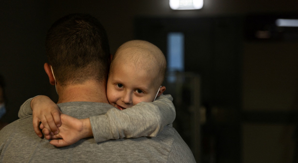  Crian&ccedil;a em tratamento de leucemia &eacute; levada pelo pai para a cave do Hospital Infantil Okhmadet, durante bombardeamento em Kiev | Umit Bektas - Reuters   