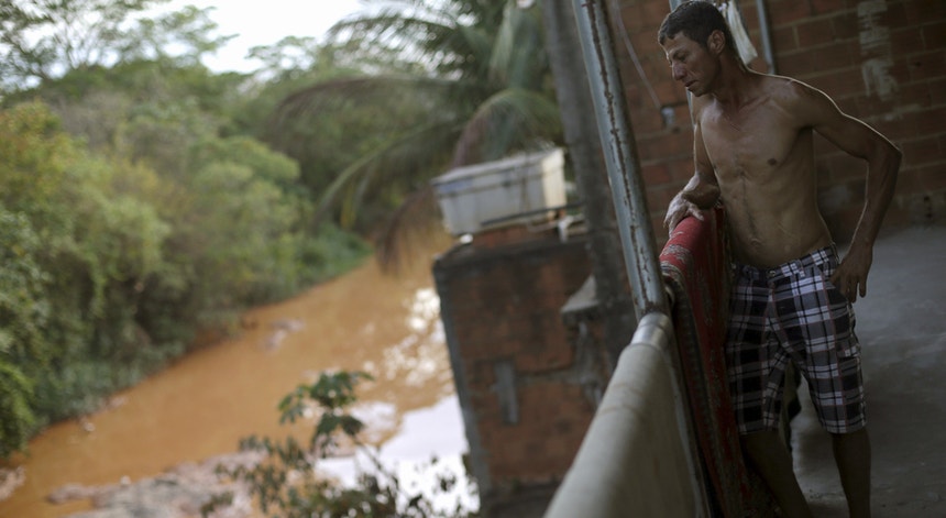 Vadilson Moreira Costa observa a partir da varanda da sua casa, na margem do Rio Doce, a água transformada em lama
