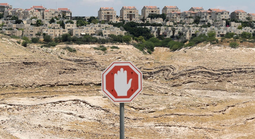 Um sinal de trânsito fotografo com o colonato israelita Maale Adumim, na Cisjordânia, em pano de fundo a 15 de Junho de 2020.
