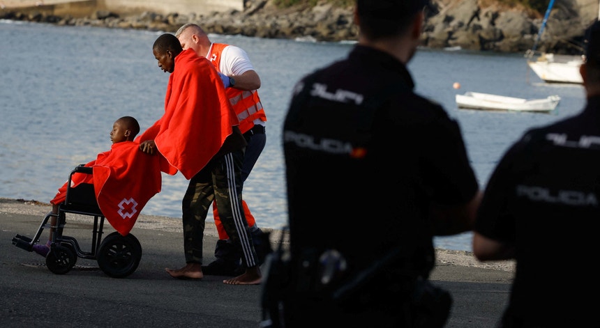 Voluntário da Cruz Vermelha com dois migrantes que desembarcaram na ilha espanhola Grã-Canária.
