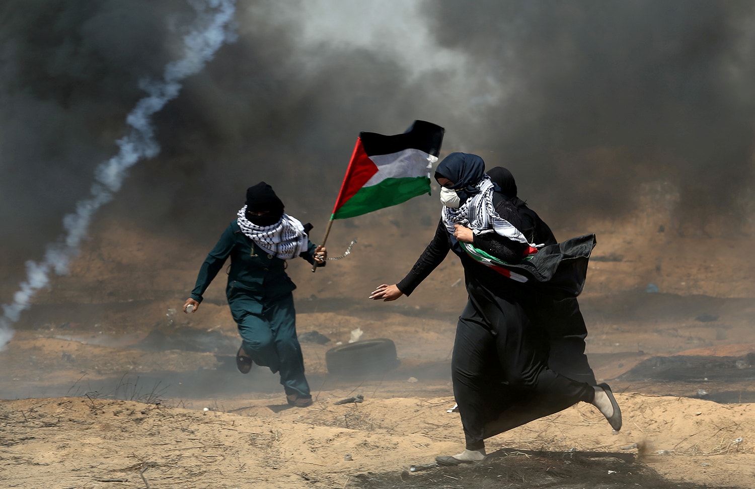  Manifestantes palestinianos fogem do g&aacute;s lacrimog&eacute;neo /Ibraheem Abu Mustafa - Reuters 