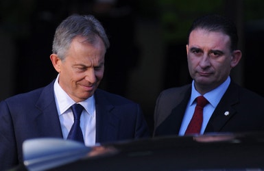 Tony Blair (à esquerda) e um dos seus guarda-costas deixam o local onde o ex-primeiro ministro teve de voltar a prestar declarações sobre o envolvimento britânico na guerra do Iraque . 
