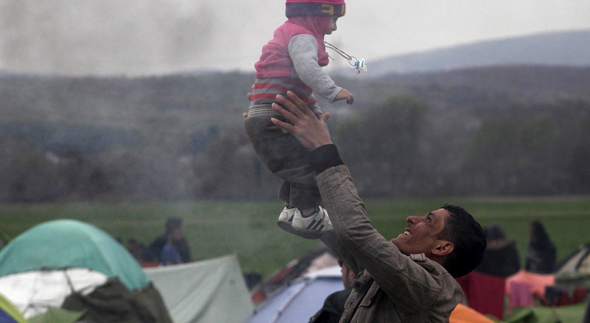 Um homem brinca com um bebé, no campo de refugiados e migrantes improvisado em Idomeni, junto à fronteira grega com a Macedónia. Mais de 13.000 pessoas amontoam-se já no campo, sem as mínimas condições de vida.
