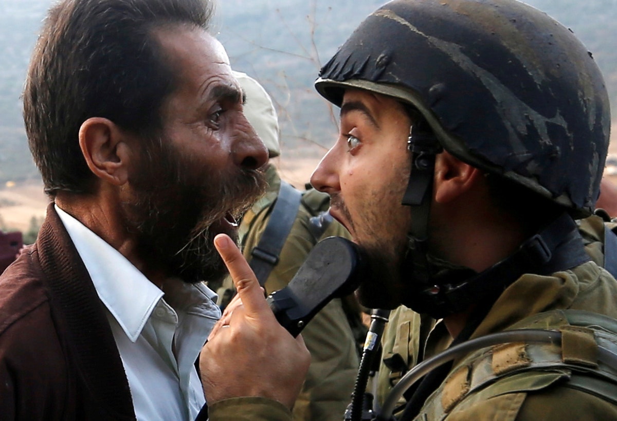  Um palestiniano discute com um soldado israelita /Mohamad Torokman - Reuters 