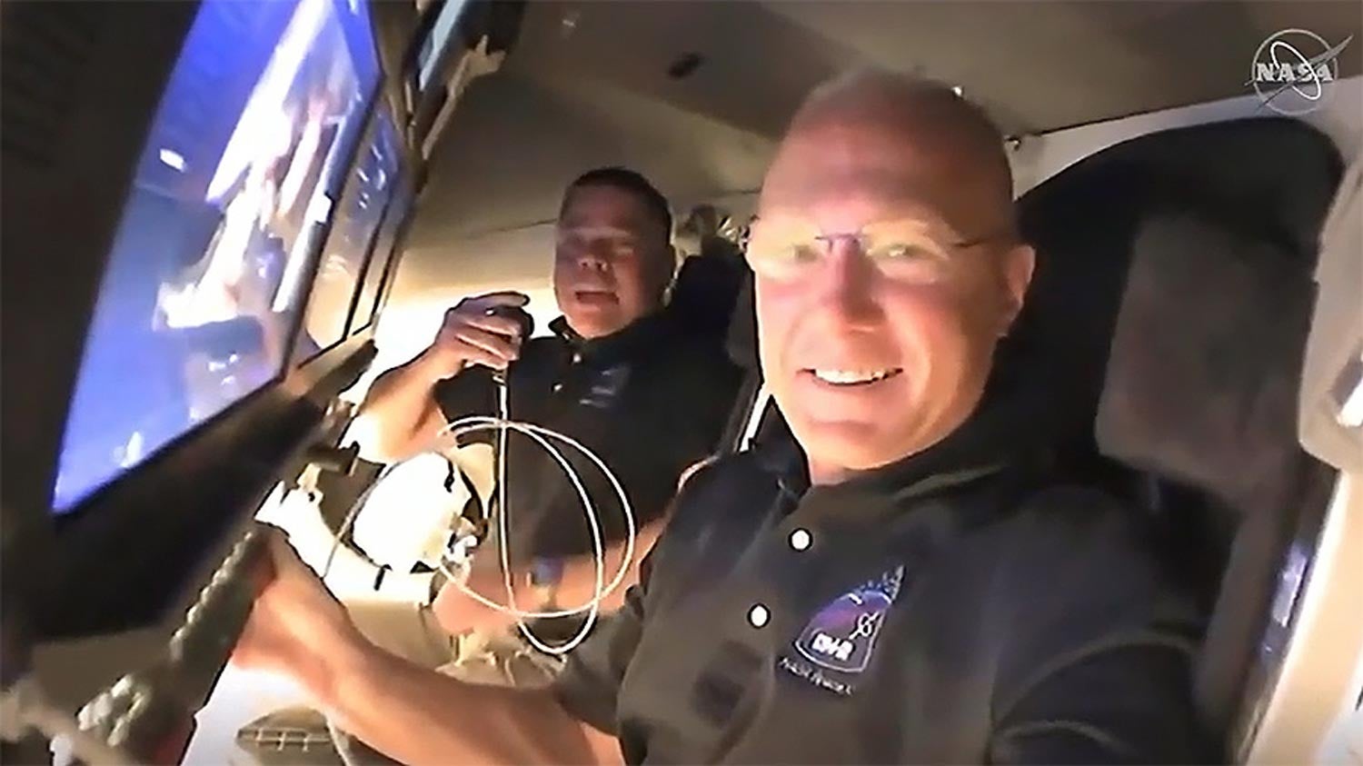Os astronautas Doug Hurley e Bob Behnken, a bordo da c&aacute;sula Crew Dragon da Space X, dia 31 de maio de 2020 ap&oacute;s acoplarem &agrave; EEI - Imagem de v&iacute;deo da NASA