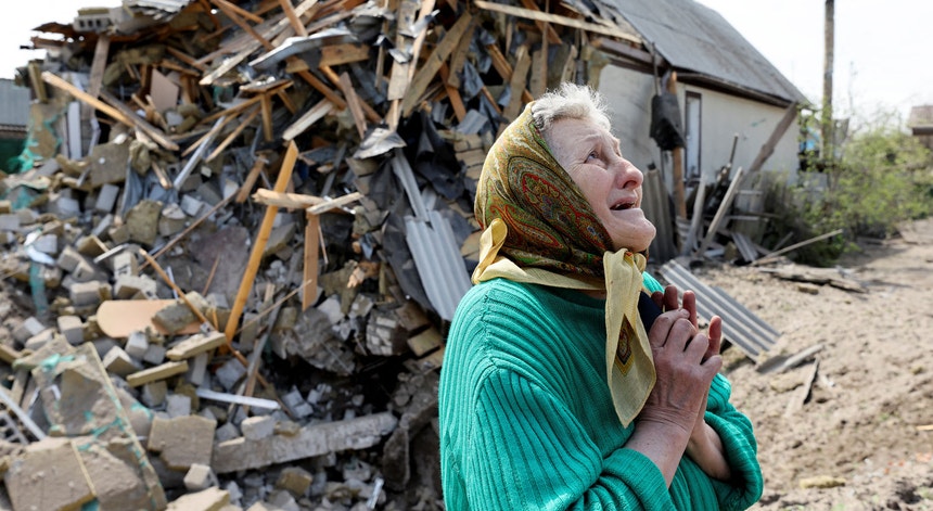 Mulher chora em Lyman, Ucrânia, rodeada de destruição
