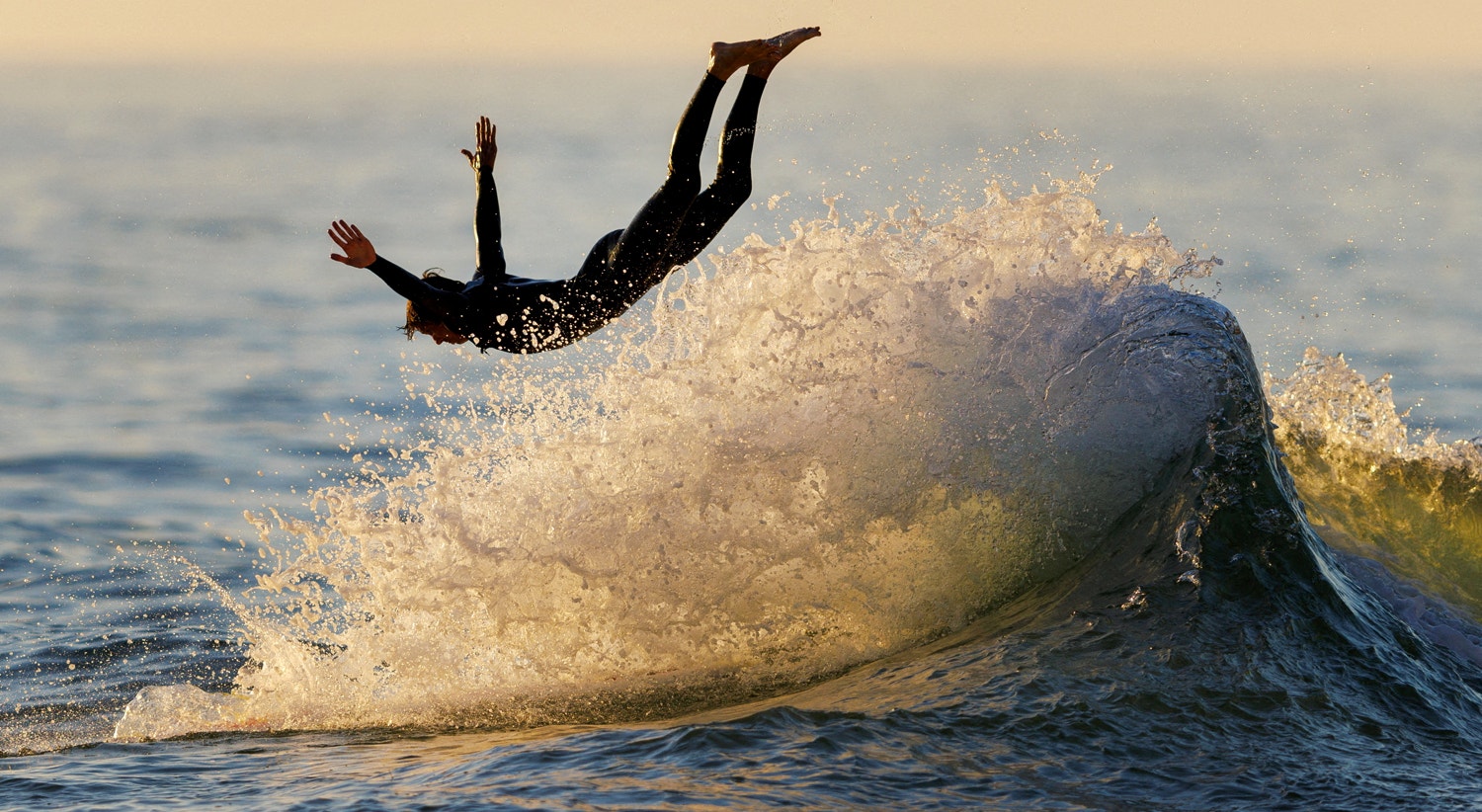  Um surfista mergulha da prancha enquanto surfa ao p&ocirc;r do sol em Encinitas, Calif&oacute;rnia, EUA, 28 de agosto | Mike Blake - Reuters 
