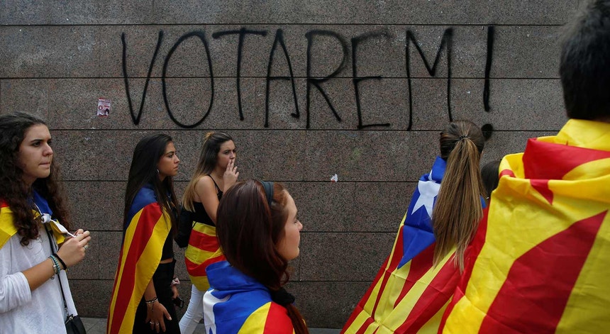 Jovens com bandeiras independentistas da Catalunha dirigem-se a uma manifestação de apoio ao referendo de 1 de outubro.
