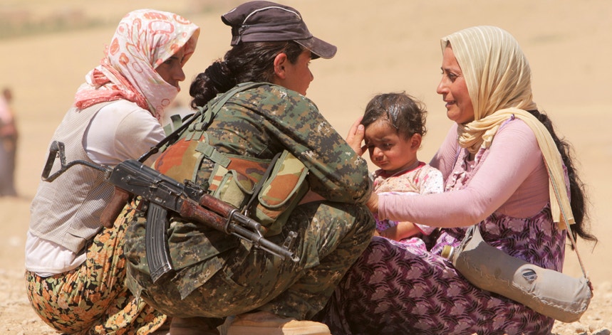 Miliciana do YPG, assistindo uma família de refugiados

