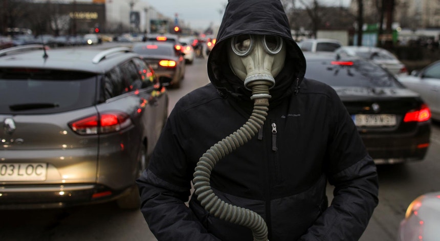Um ativista chama a atenção para a poluição atmosférica ao andar no meio do trânsito numa rua de Bucareste, Roménia, em fevereiro de 2020

