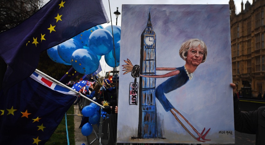O pintor Kaya Mar empunha a caricatura da primeira-ministra britânica Theresa May durante uma manifestação nas imediações do Parlamento em Londres
