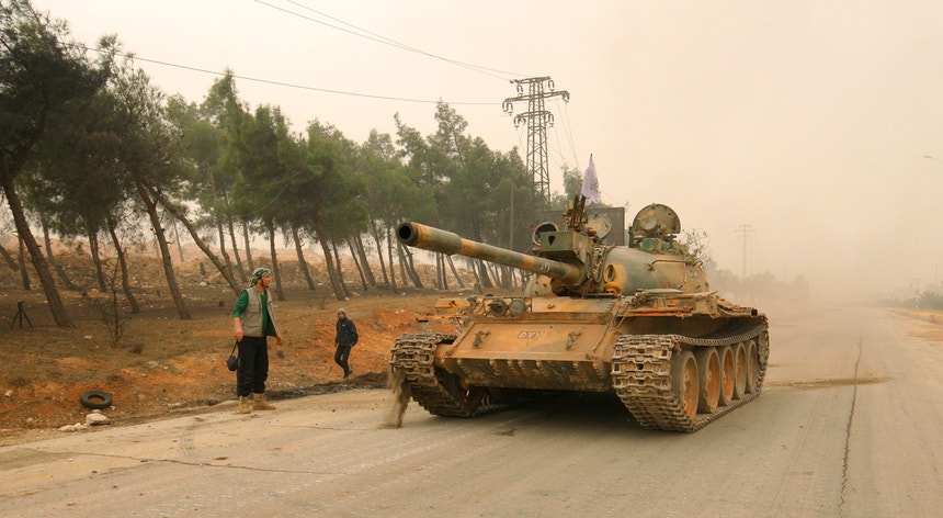 Um carro armado de militantes rebeldes circula na zona ocidental de Alepo 
