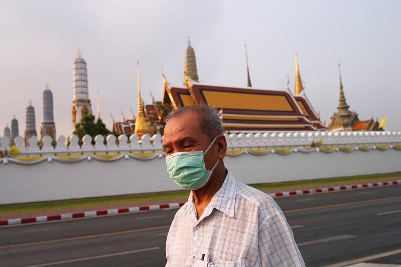 Um homem com uma máscara para prevenir a infeção do novo coronavírus em Bangkok, na Tailândia. 
