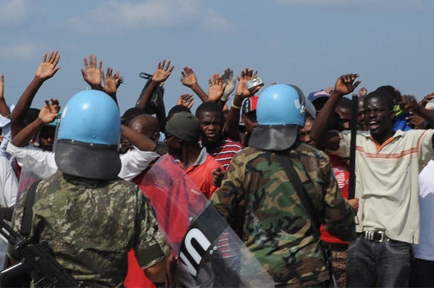  Haitianos em protesto fazem ecoar palavras de ordem, pedindo assist&ecirc;ncia. Um grupo de capacetes azuis procura conter a manifesta&ccedil;&atilde;o 