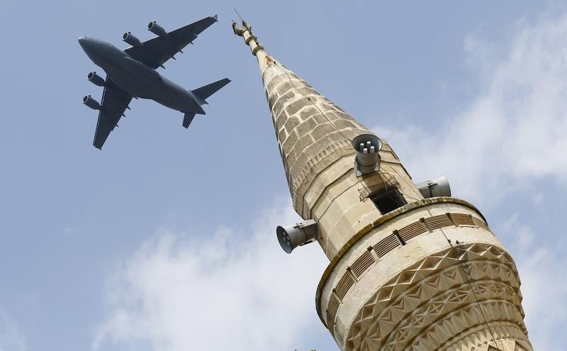 Um Boeing C-17A da For&ccedil;a A&eacute;rea dos EUA sobrevoa um minarete ap&oacute;s levantar voo da base de Adana, na Turquia, a 12 de agosto de 2015 Foto: Reuters