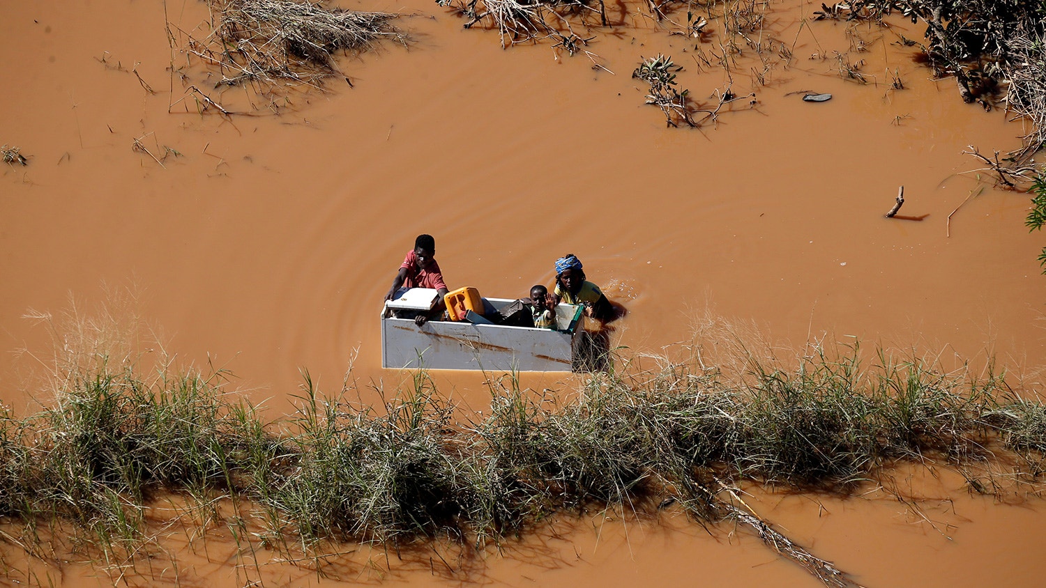  Crian&ccedil;a &eacute; transportada num frigor&iacute;fico durante as cheias provocadas pelo ciclone Idai, em Buzi, Mo&ccedil;ambique. 21 de mar&ccedil;o de 2019. | Siphiwe Sibeko - Reuters 