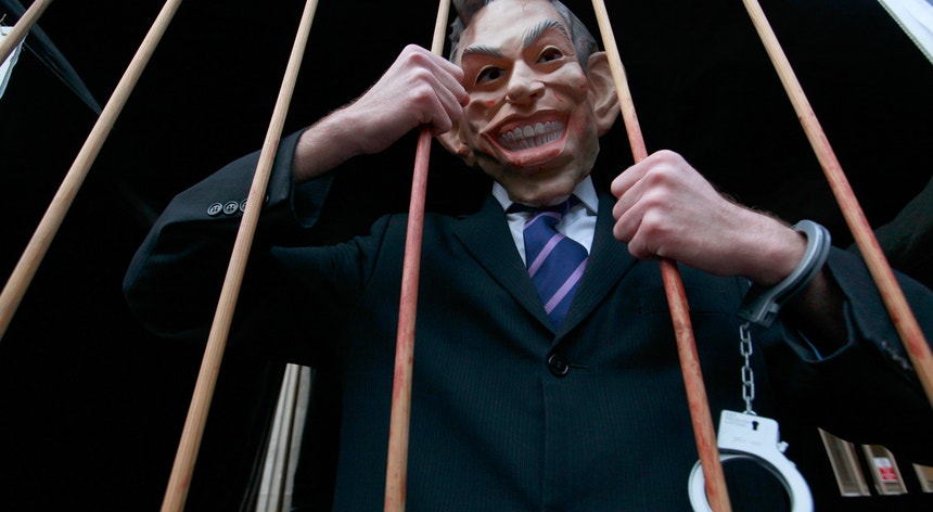 Um manifestante contra a participação do Reino Unido na guerra do Iraque, mascarado de Tony Blair
