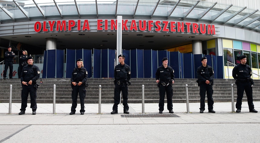 Dois efetivos da polícia alemã, equipados com coletes à prova de bala, patrulham uma rua de Munique
