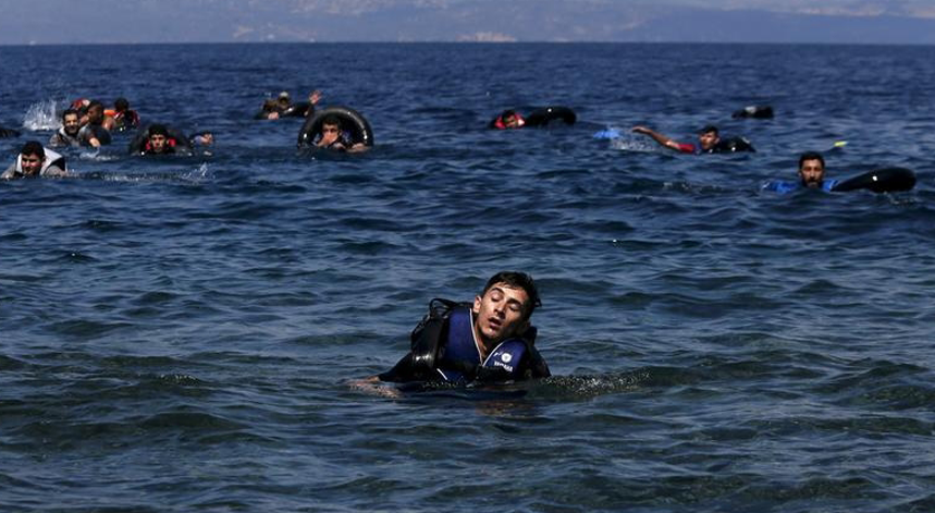 Um refugiado exausto nada para a costa grega de Lesbos após o barco pneumático em que seguia se ter afundado a 12 de setembro de 2015 
