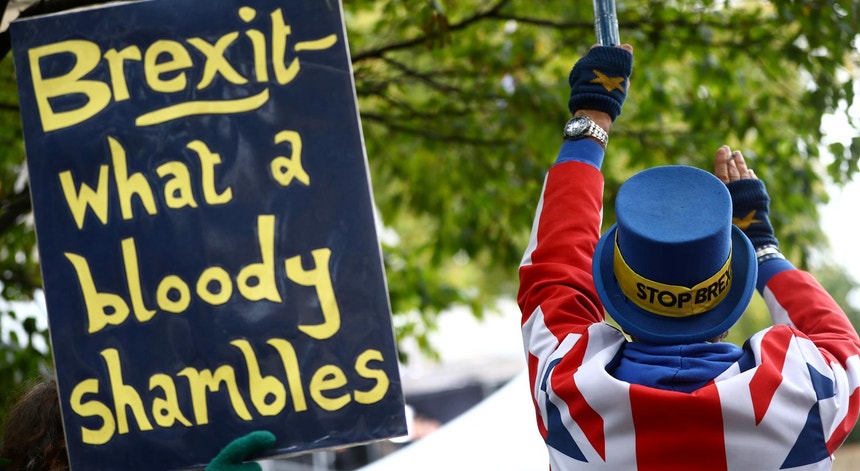 Um cartaz empunhado por um opositor do Brexit junto às casas do Parlamento, em Westminster, em Londres
