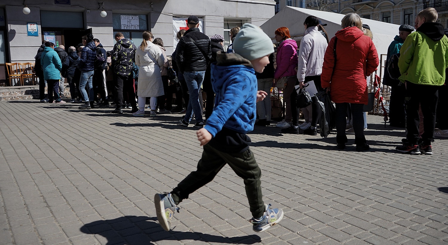  Uma crian&ccedil;a brinca frente a uma fila de refugiados das zonas de Kherson e Mykolaiv. 