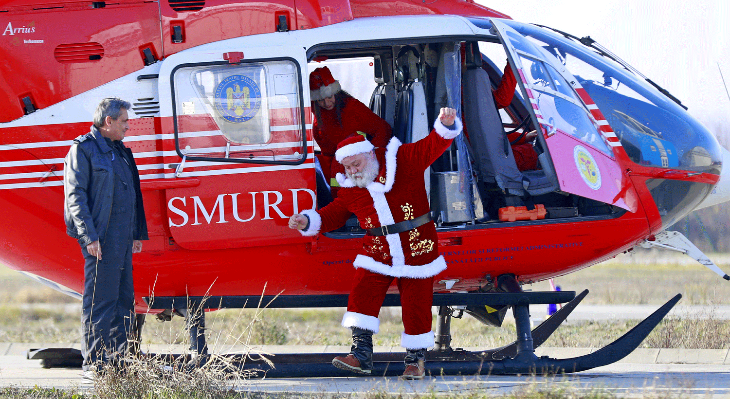  Pai Natal romeno trocou a tradicional carruagem de renas por um helic&oacute;ptero de resgate de emerg&ecirc;ncia para um espect&aacute;culo dedicado &agrave;s crian&ccedil;as, familiares dos trabalhadores no centro de resgate de emerg&ecirc;ncia no Centro de Avia&ccedil;&atilde;o do Minist&eacute;rio do Interior em Bucareste, Rom&eacute;nia. Cr&eacute;ditos: EPA/ROBERT GHEMENT 