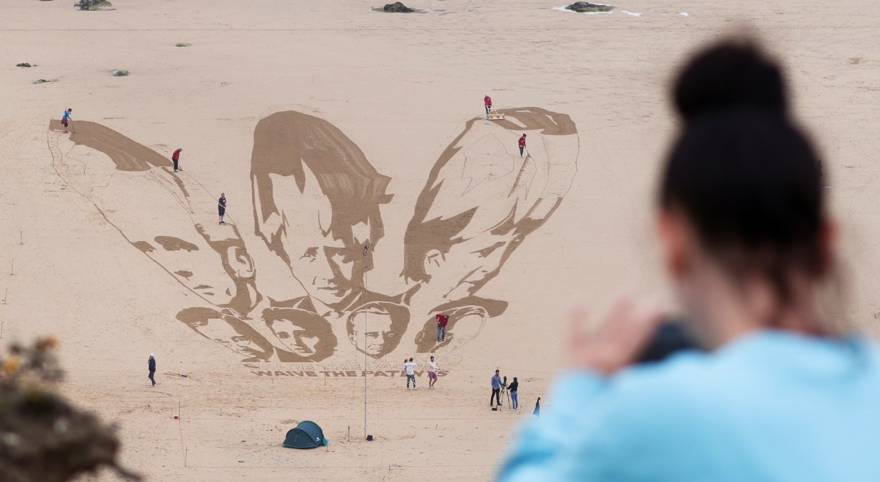  O grupo de campanha Avaaz trabalha para criar uma obra de arte gigante na areia da praia, retratando os rostos dos l&iacute;deres do G7 ao lado de uma mensagem escrita na areia: &quot;Partilha a vacina, renuncia &agrave;s patentes&quot;, em Watergate Bay Beach | Tom Nicholson - Reuters 