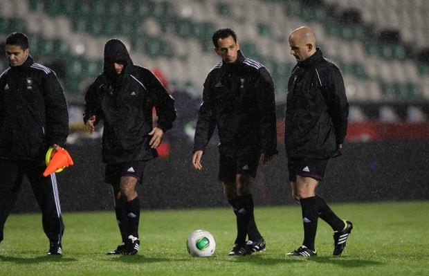 O árbitro Pedro Proença analisa as condições do campo durante a forte chuva que cai no campo do Estádio do Bonfim 
