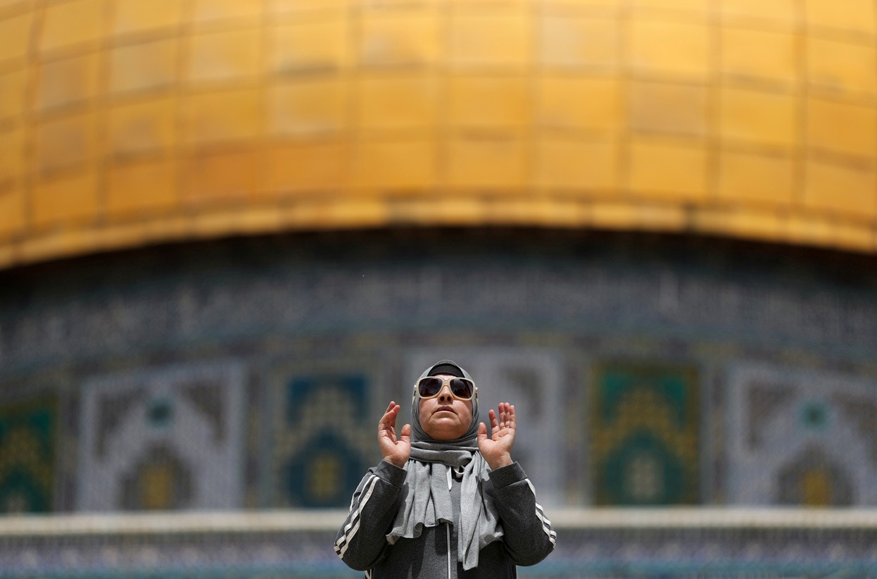  Israel. &Uacute;ltima Sexta-feira do Ramad&atilde;o. Mulher mu&ccedil;ulmana reza junto ao Nobre Santu&aacute;rio | Ammar Awad - Reuters 