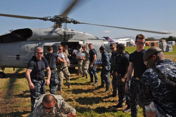  Militares norte-americanos carregam um helic&oacute;ptero com &aacute;gua e alimentos que aos poucos chegam &agrave; popula&ccedil;&atilde;o do Haiti 