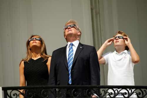 Donald Trump e a mulher, Melania, a observar o eclipse total do Sol a partir de uma varanda da Casa Branca, co o filho mais novo do Presidente dos EUA Foto: Reuters Donald Trump e a mulher, Melania, a observar o eclipse total do Sol a partir de uma varanda da Casa Branca, co o filho mais novo do Presidente dos EUA Foto: Reuters