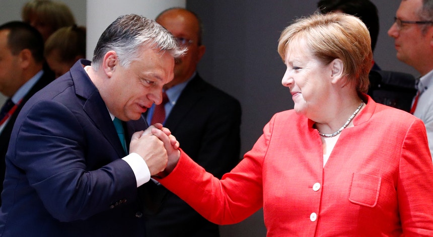 Viktor Órban, primeiro-ministro húngaro, cumprimenta a chanceler alemã, Angela Merkel, durante a cimeira europeia 
