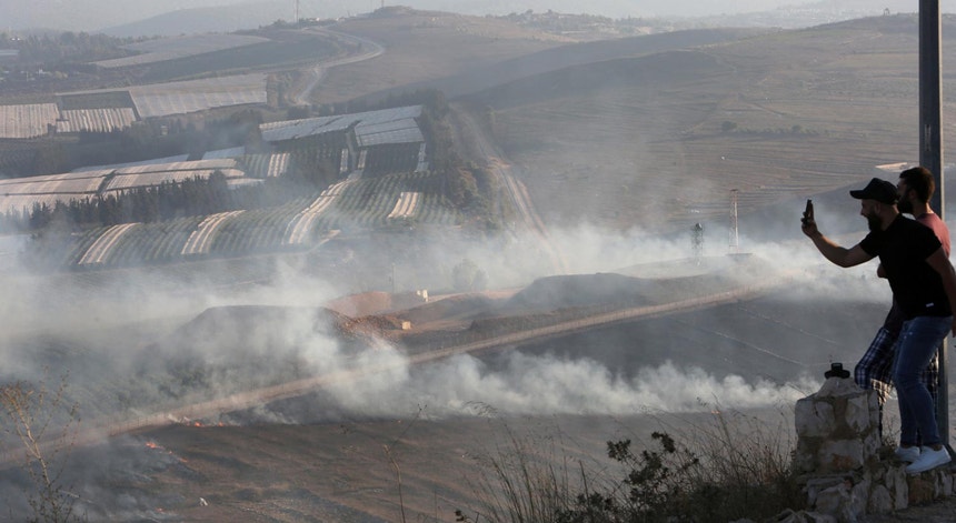 Um homem capta imagens do fumo causado pelos bombardeamentos israelitas contra a aldeira de Maroun al-Ras, a 01 de setembro de 2019.
