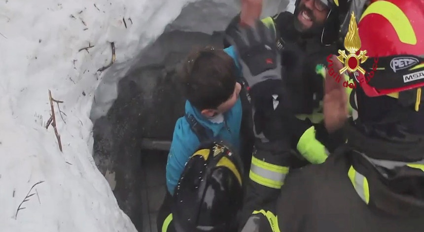 Bombeiros italianos em ação resgatam uma criança dos escombros.
