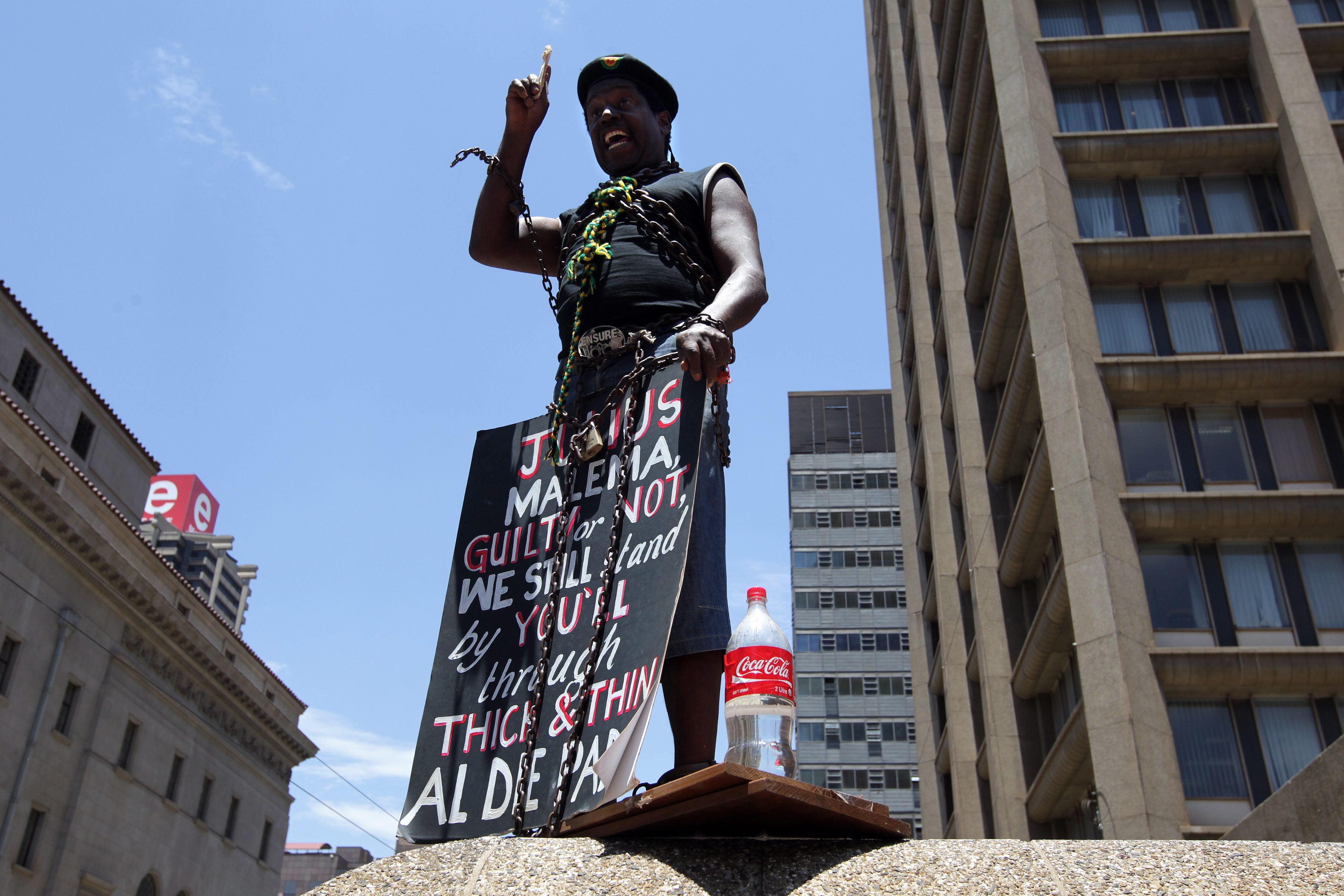 Um apoiantes de Malema discursa perante um pequeno grupo reunido &agrave; porta da sede do ANC, em protesto pela demiss&atilde;o do l&iacute;der da Liga da Juventude