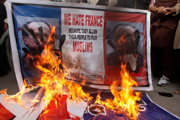 Manifestantes no Paquistão queimam bandeira e retratos franceses. (Fotografia: Naseer Ahmed, Reuters)